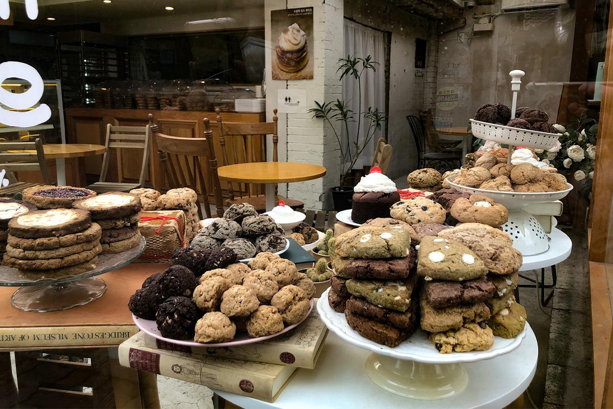 Toko Ikseon-dong menampilkan aneka kue dan makanan manis di rak dapur kayu.