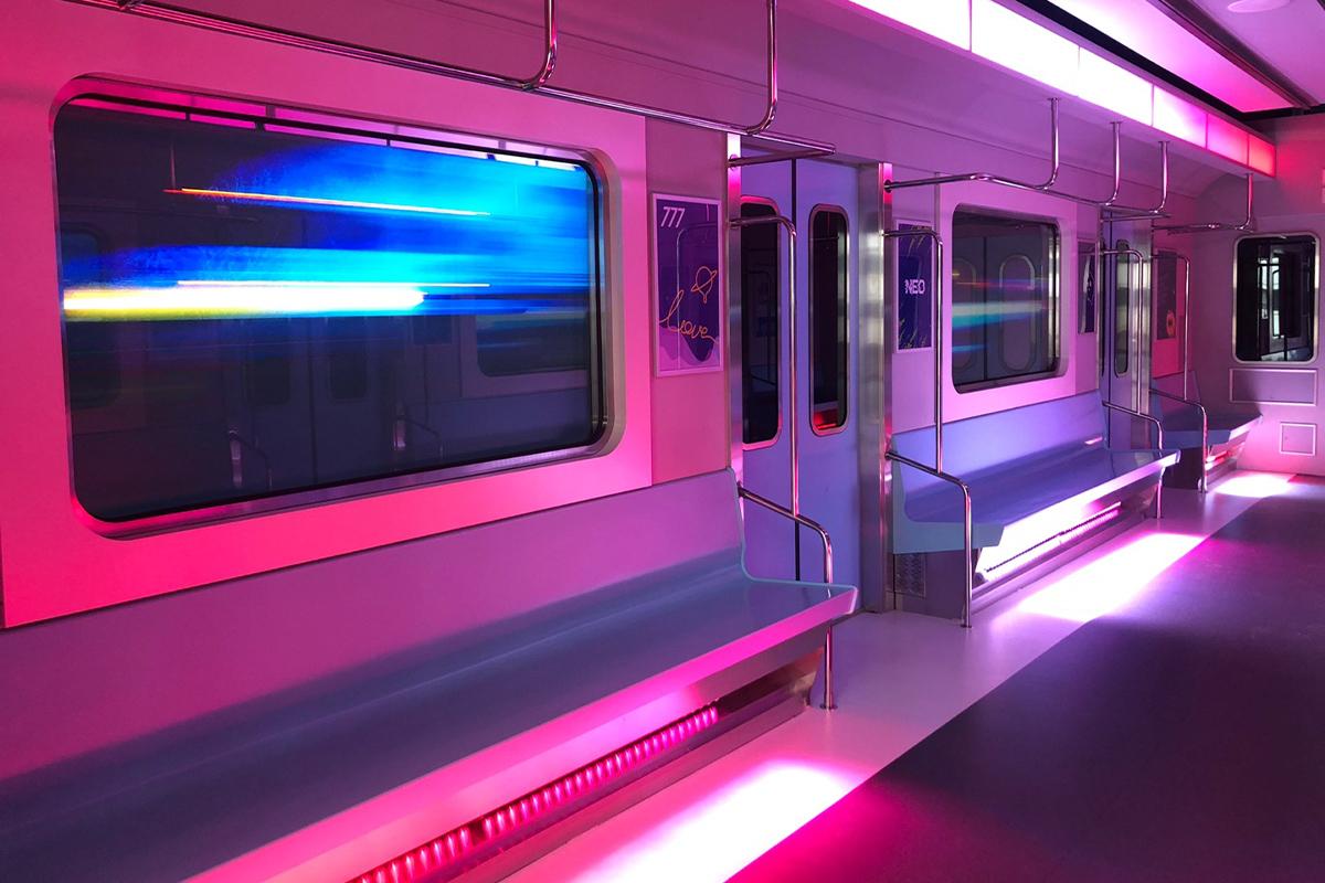 Interior kereta bawah tanah dengan pencahayaan lampu neon di HiKR Ground, tempat pengalaman K-pop di Seoul.