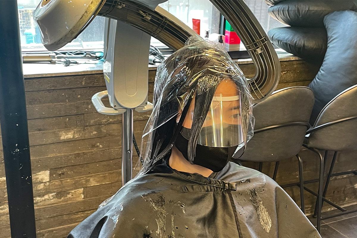 沙龍內的一位客人在加熱護髮過程中舒適地放鬆。