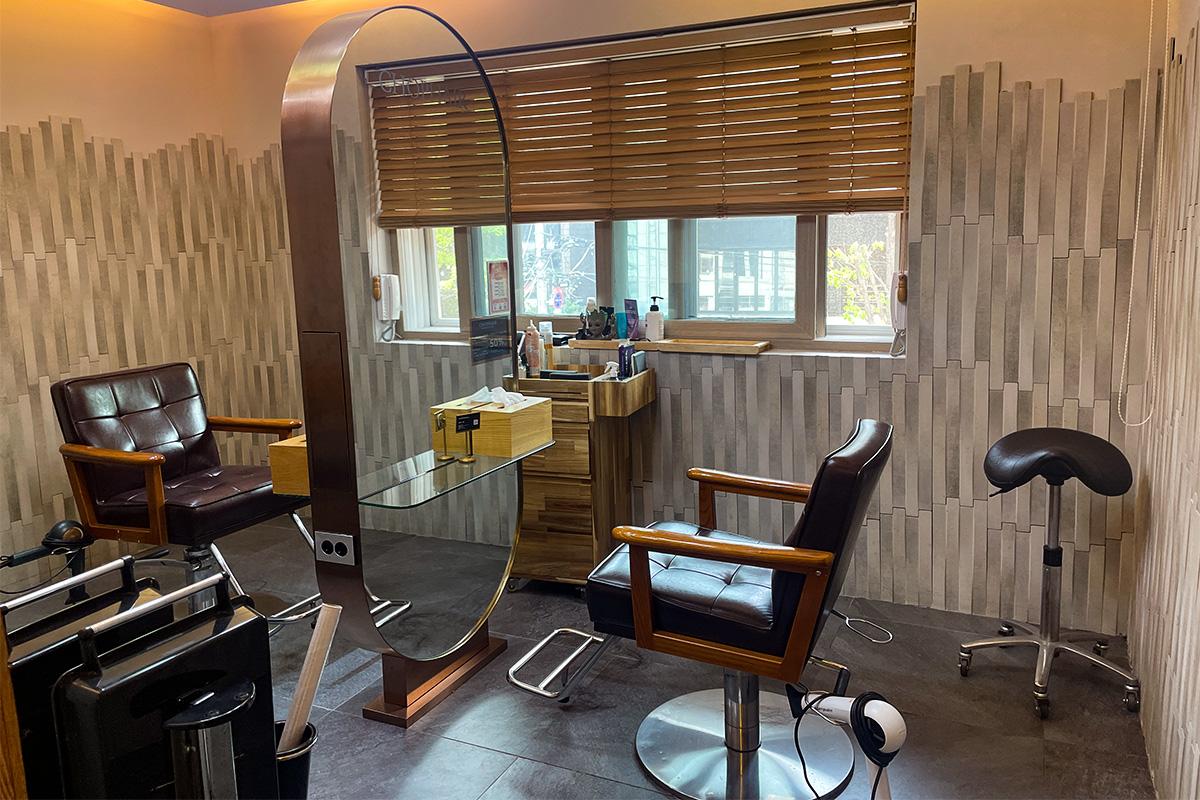 私人剪髮區,設有時尚鏡子和木製美容椅。
