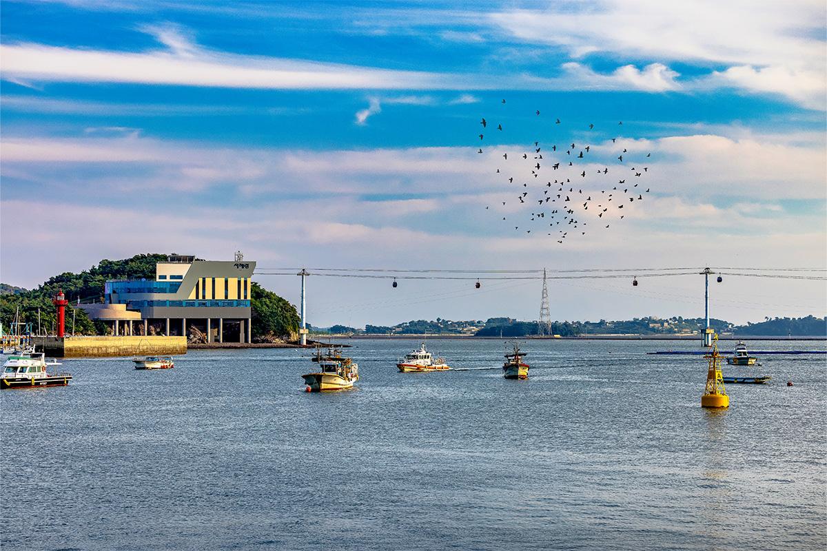 Helipuerto y barcos cerca de la Isla Jebudo en Corea, con el teleférico Seohae-Rang visible en el fondo.