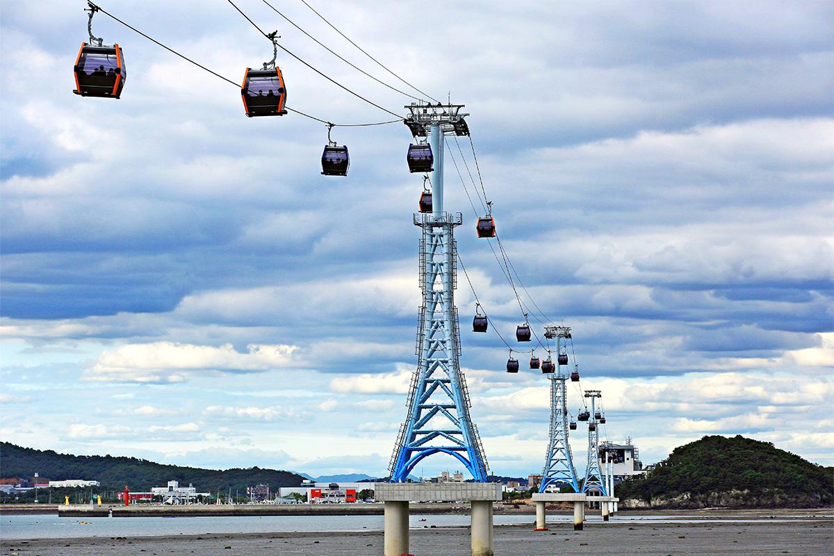 Teleférico Seohae-Rang con una línea de cabinas cruzando el mar en un día nublado cerca de Ansan, Corea.