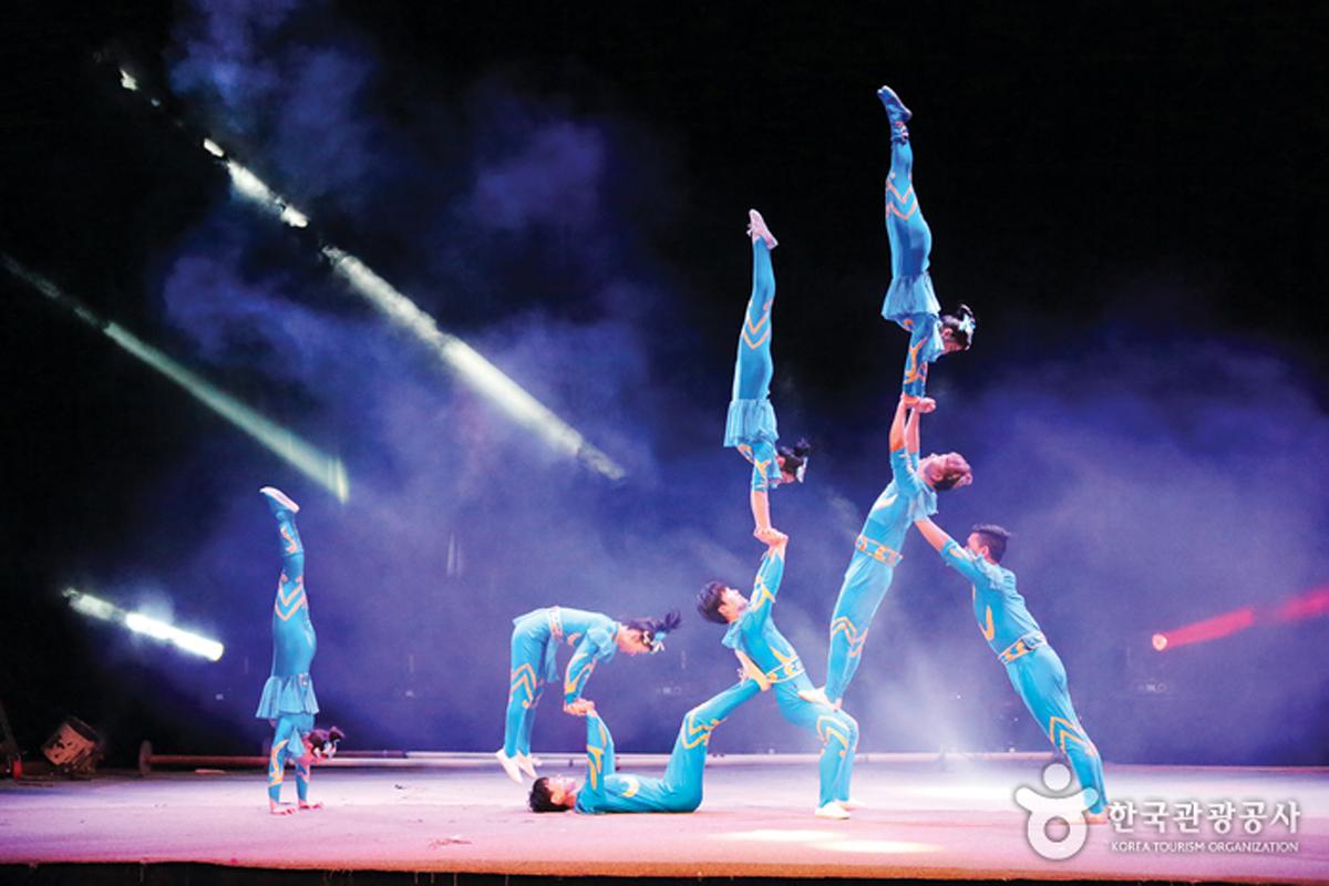 Grupo de acróbatas formando una pirámide humana en el escenario en el Circo Dongchun, Corea.