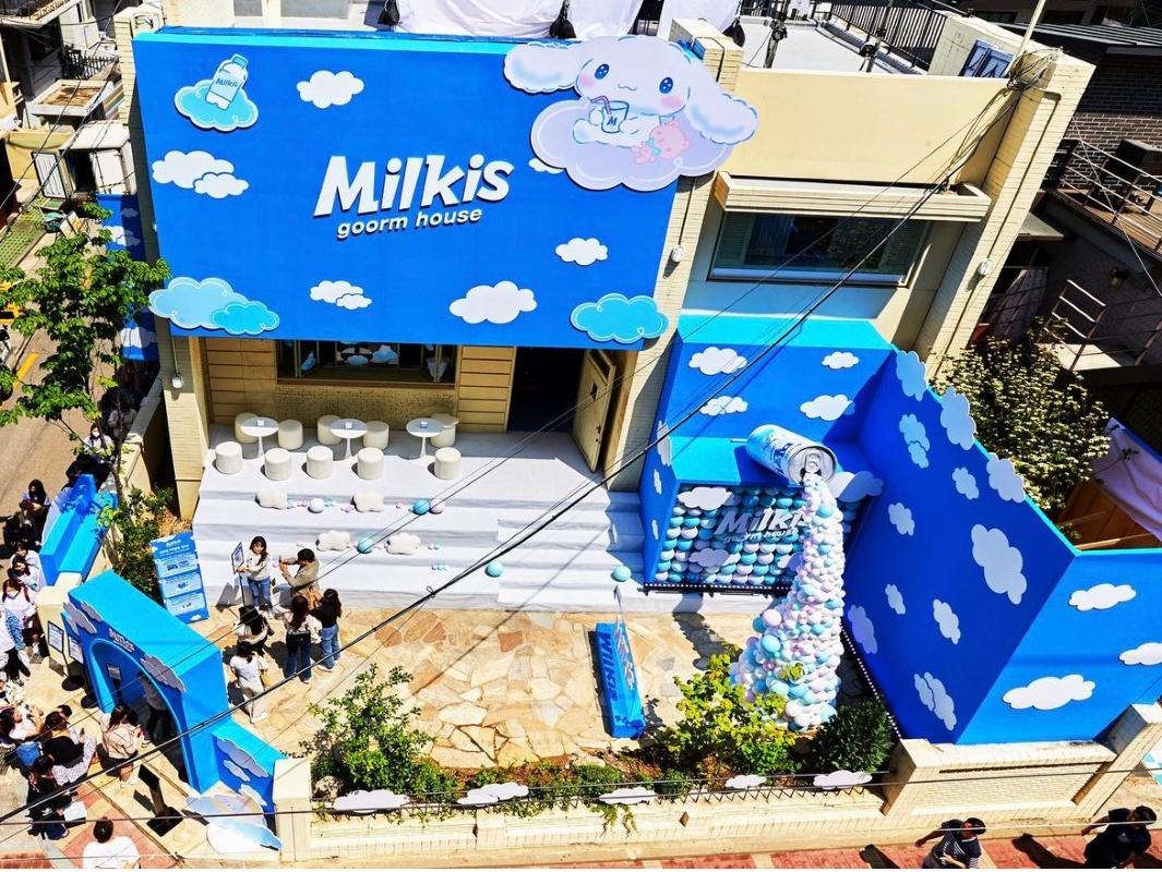 シナモロールとMilkisのコラボカフェの入口の様子です。訪問者が入り口に集まっており、待合登録制システムが設置されています。