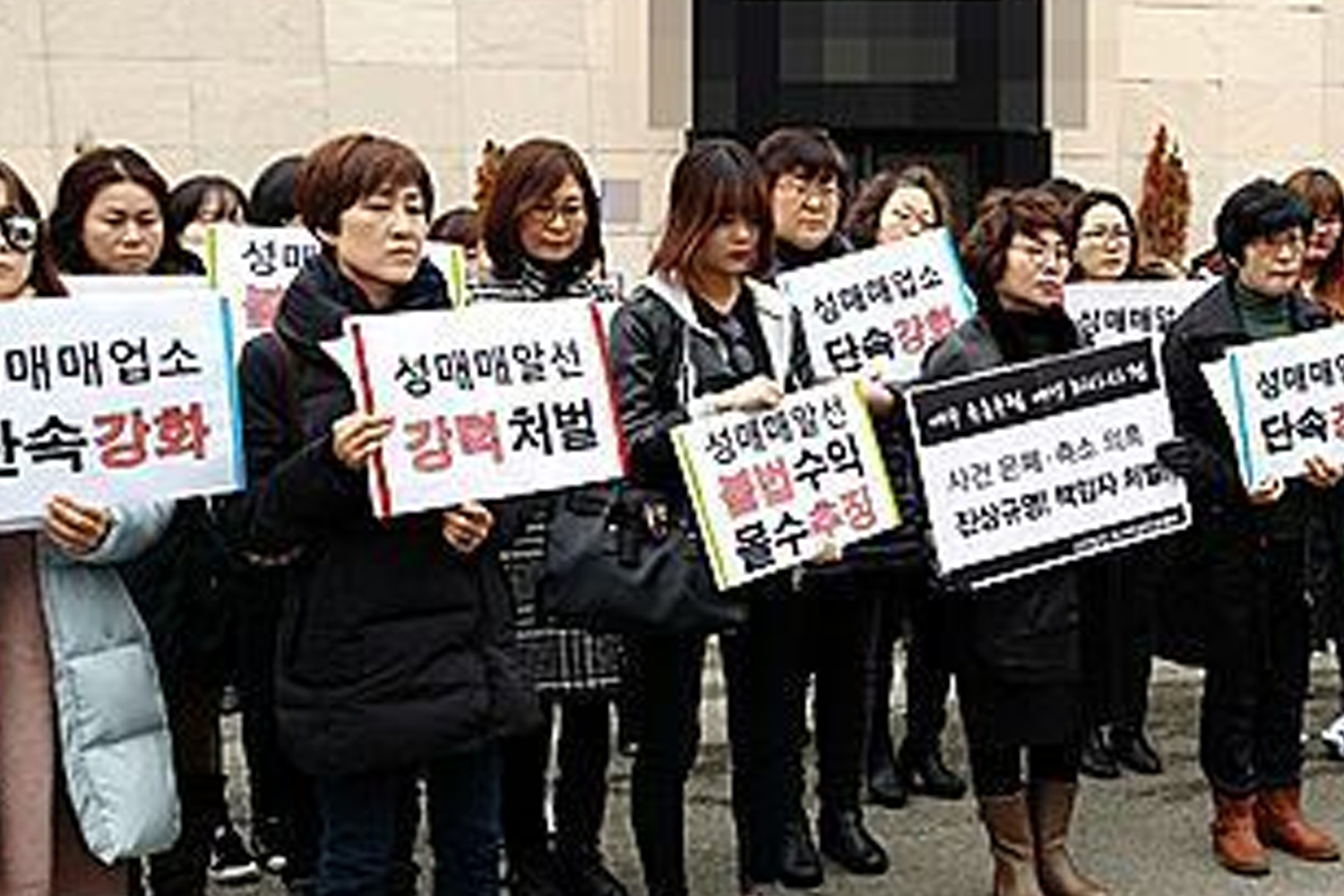 Group of people holding signs during a public protest in South Korea.