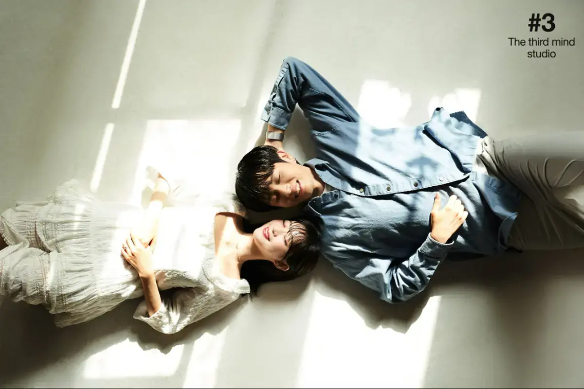 摄影棚内情侣合影，躺在阳光洒落的地面上，浪漫宁静的氛围