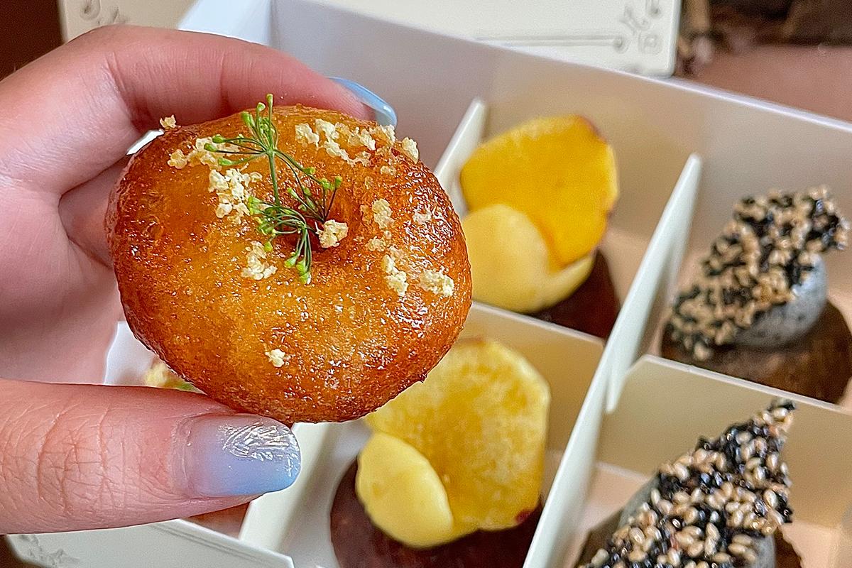 Assortiment coloré de beignets Jooak coréens, garnis d'une variété de garnitures expressives dans leur boîte open-air.