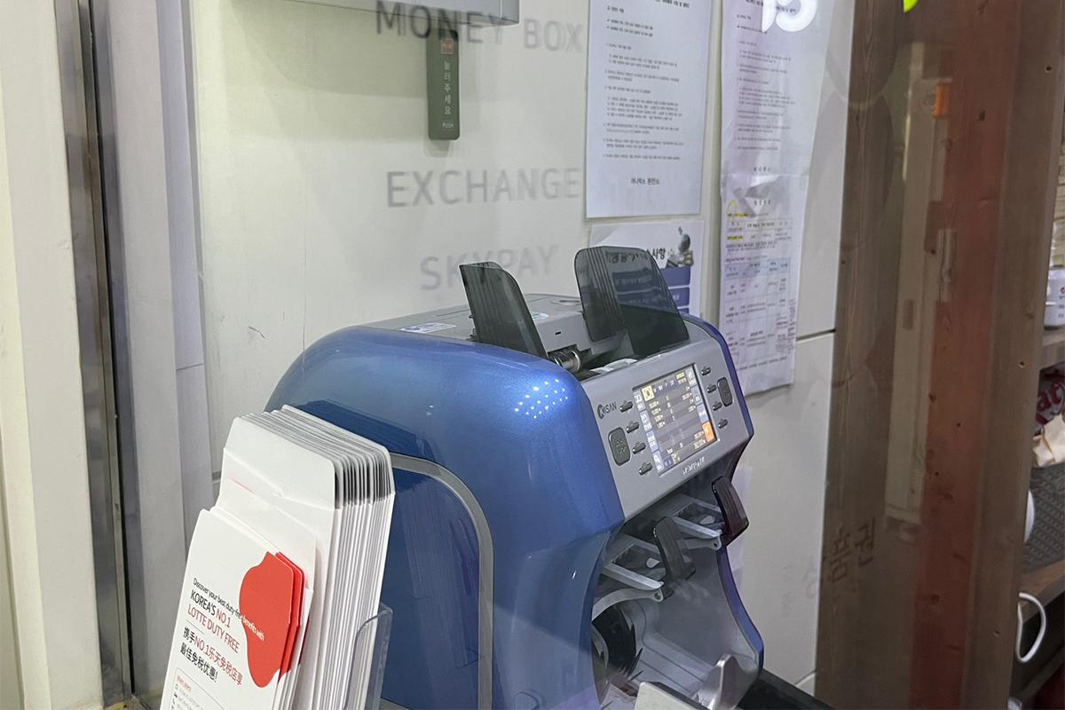 Calculator and currency exchange screen on the counter at Money Box Haeundae branch with currency options.