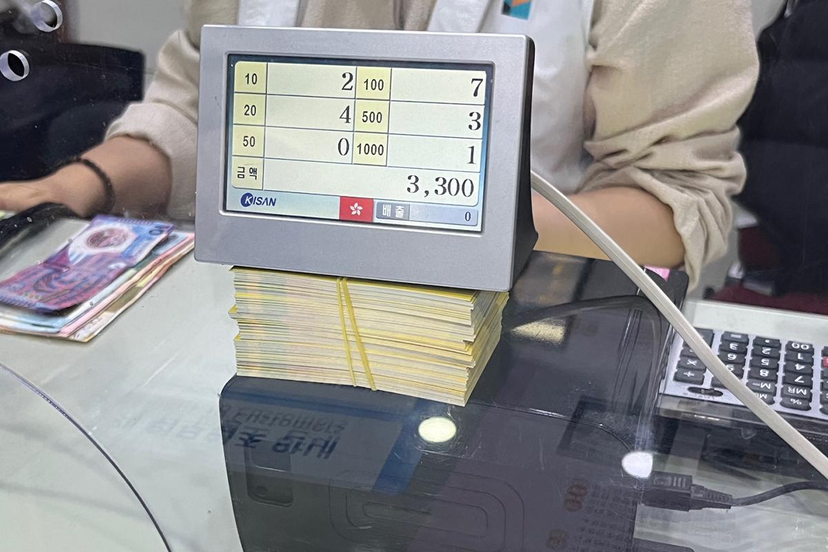 Currency counter machine on the counter at Money Box Haeundae branch, ready for note counting.