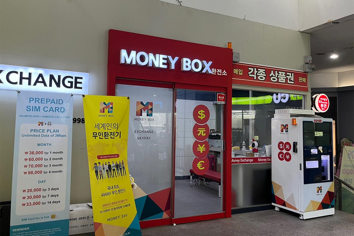 Entrance of Money Box Haeundae branch with banners promoting currency exchange and other services.