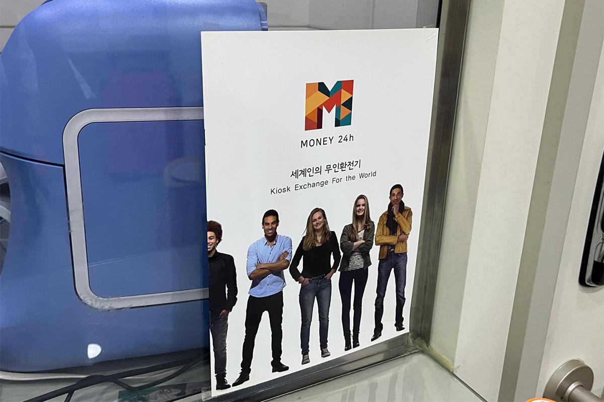 Counter area at Money Box Haeundae branch with a calculator and instructions for customers about currency exchange.