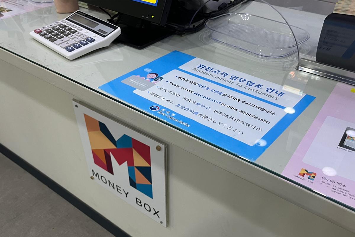Money exchange rate display screen inside the Money Box Haeundae branch, updating foreign currency rates.