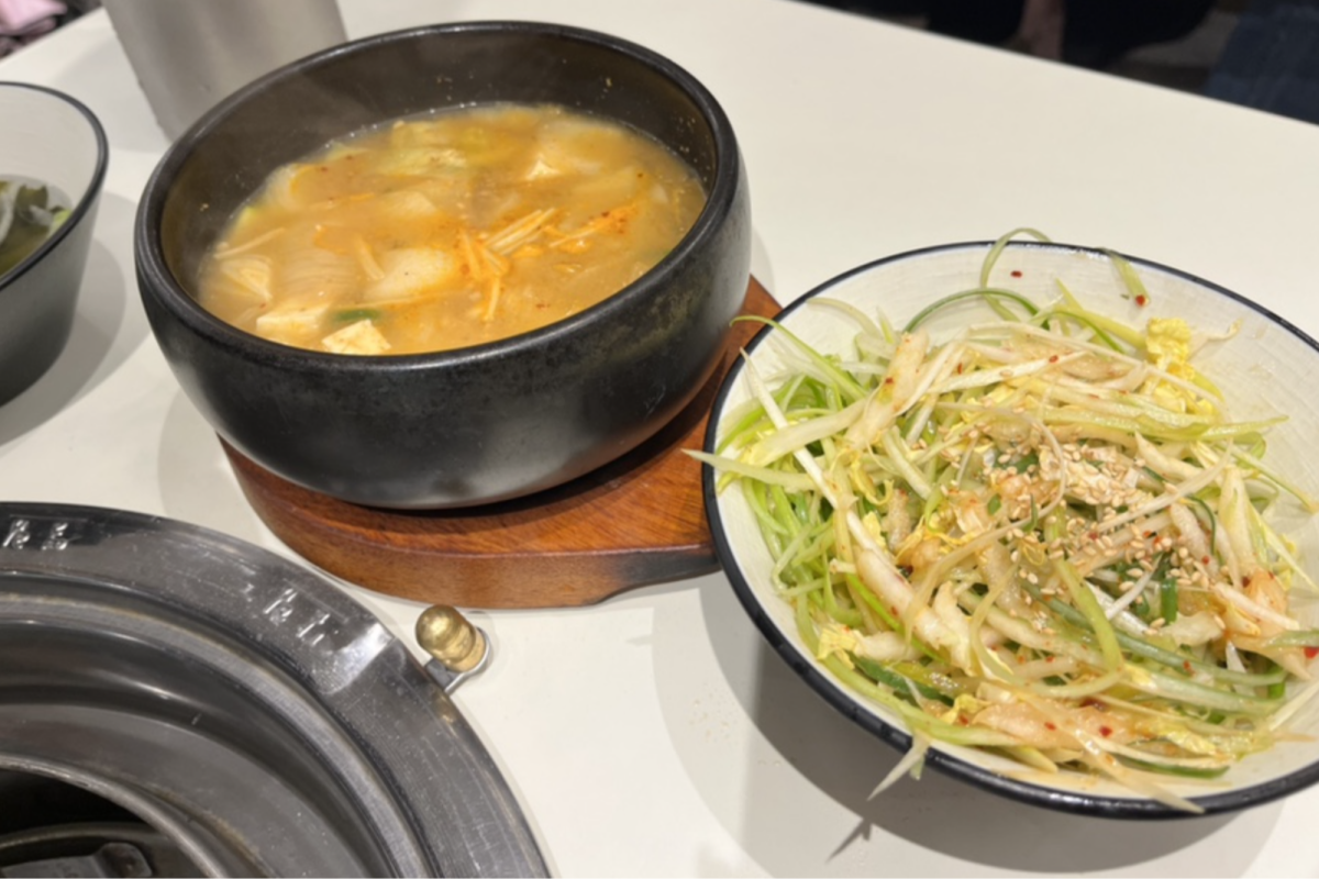 Sopa de pasta de soja y ensalada servidas como cortesía en la barbacoa Dadokine de Hongdae.
