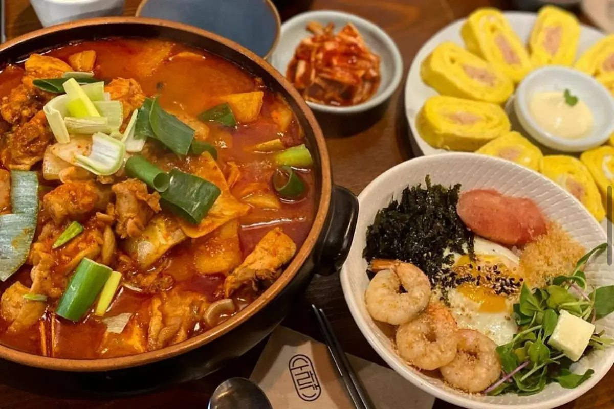 Estofado de pollo picante Dakdoritang servido con acompañamientos coreanos tradicionales en Sooragan, Hongdae.