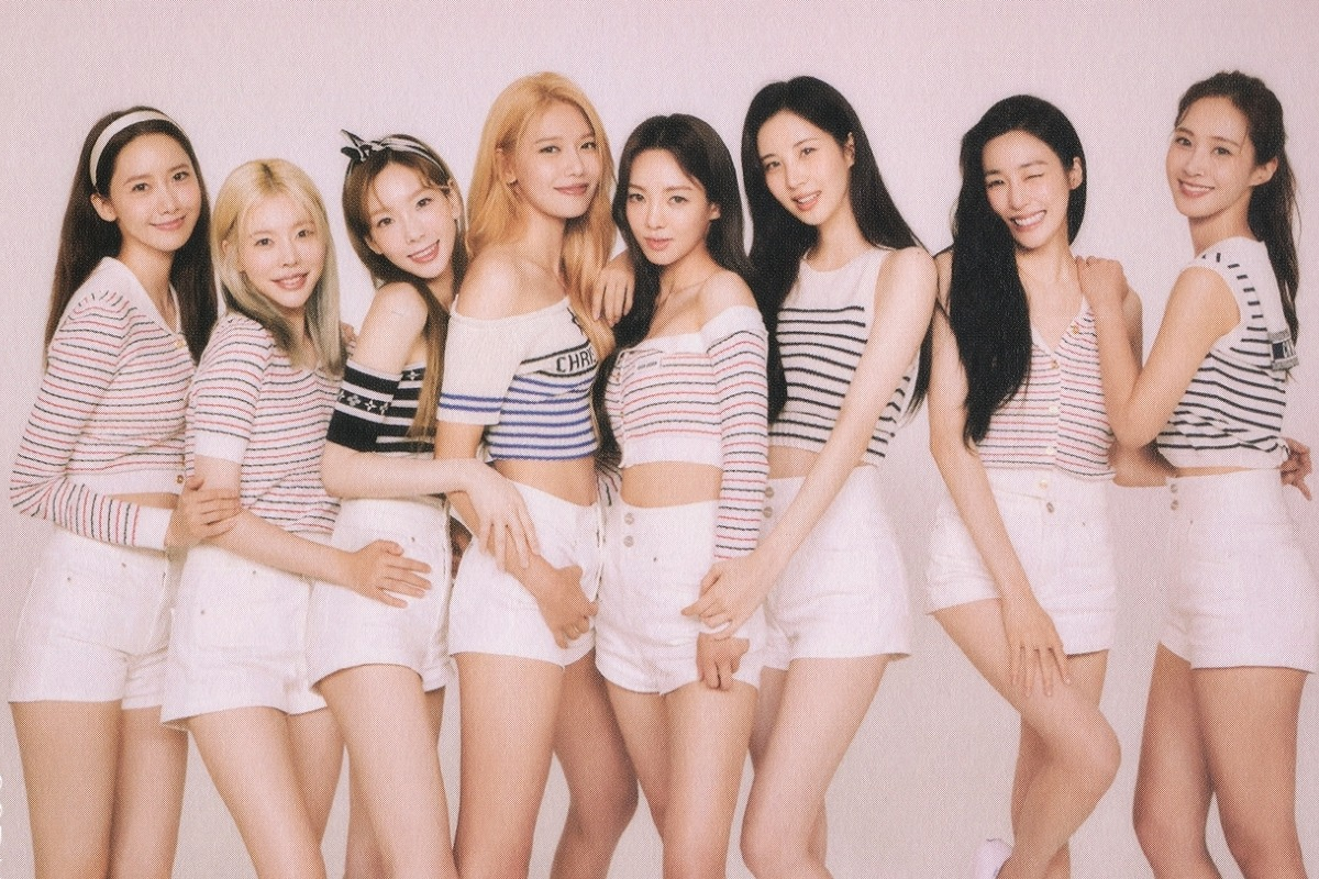 少女時代成員穿著粉色系舞台服飾，在合照時展現青春活力的團體形象。