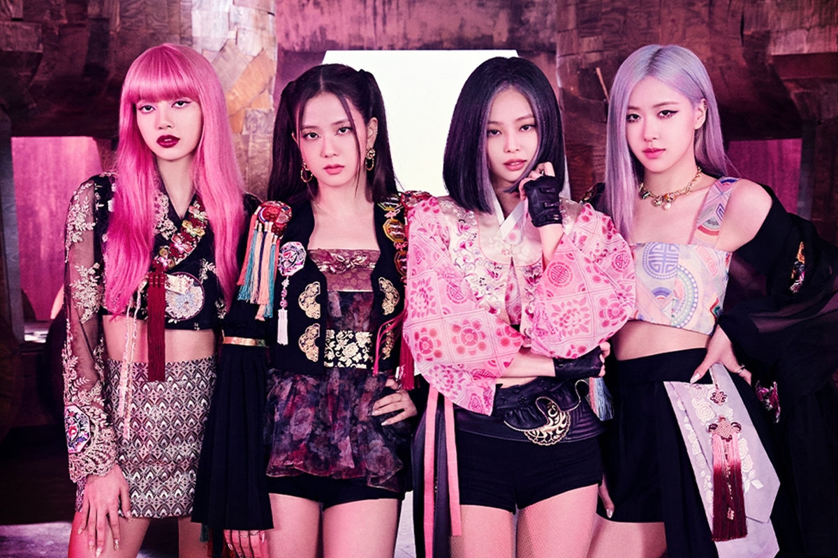 身著現代化流行服飾的女團成員們，站在色彩豐富的背景前，散發著清新與活力。