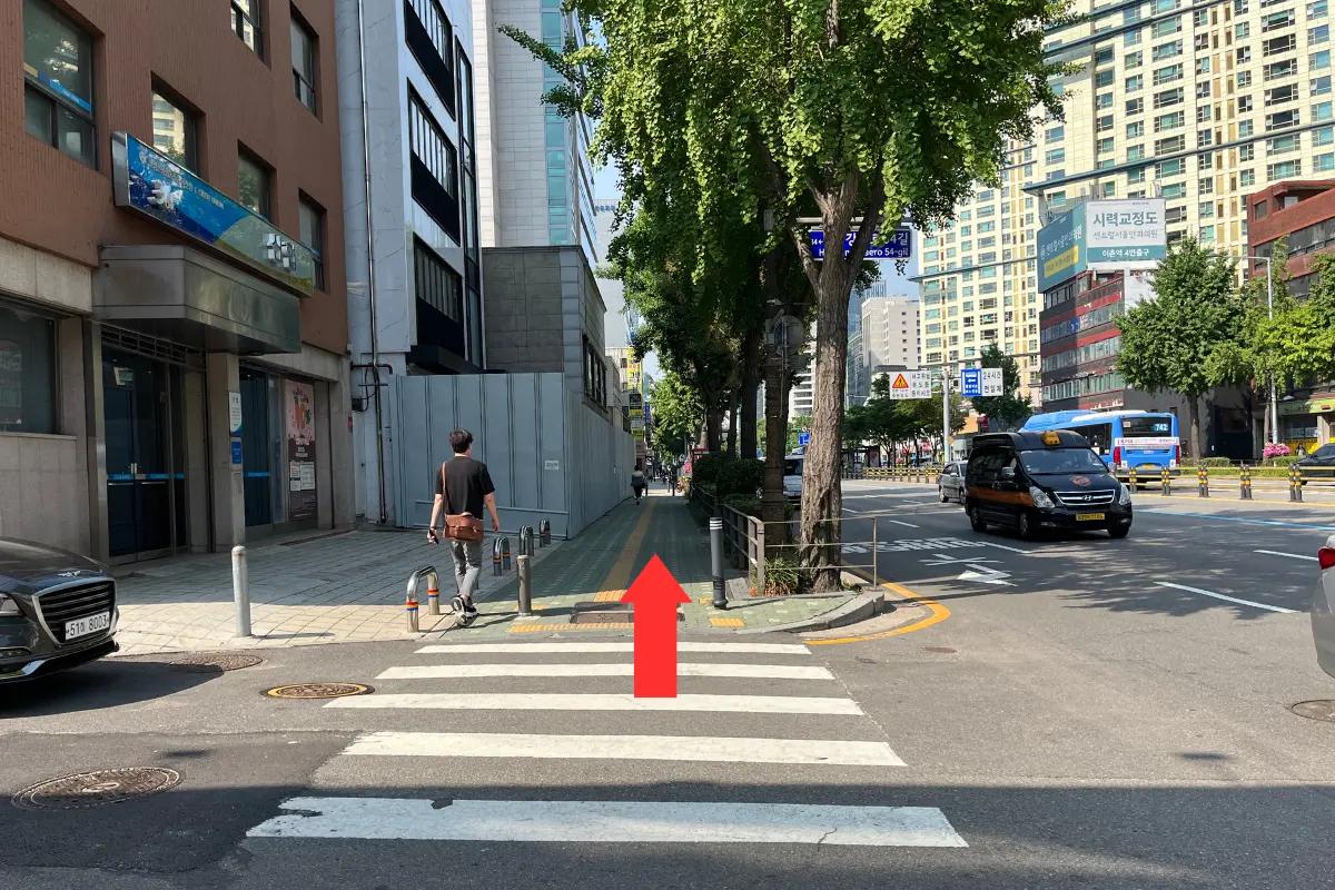 Cruce de calles en la dirección a Teddy Beurre House, con flechas guías para orientación en el camino.