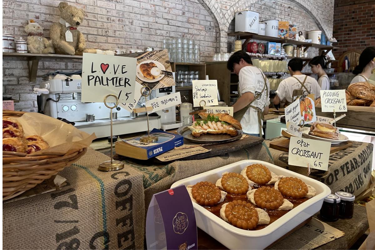 Una variedad de productos de panadería como palmiers y croissants expuestos en la barra de Teddy Beurre House.