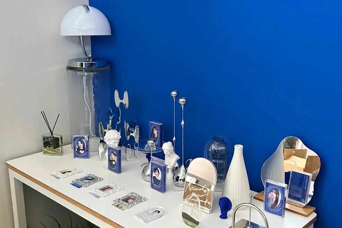 青い壁を背景にした展示スペース、各種フォトアイテムが並ぶ。