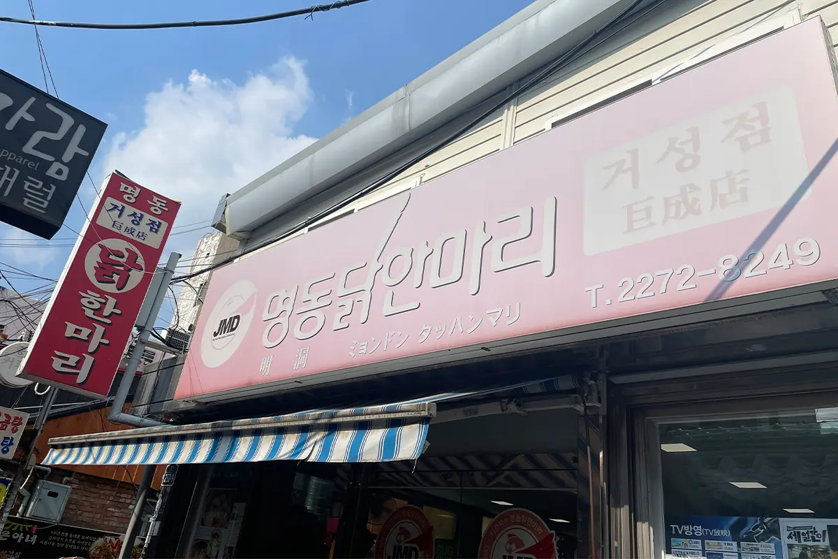 在市場巷子內直行時，顯示的有人排隊等候和商店裝飾燈光。