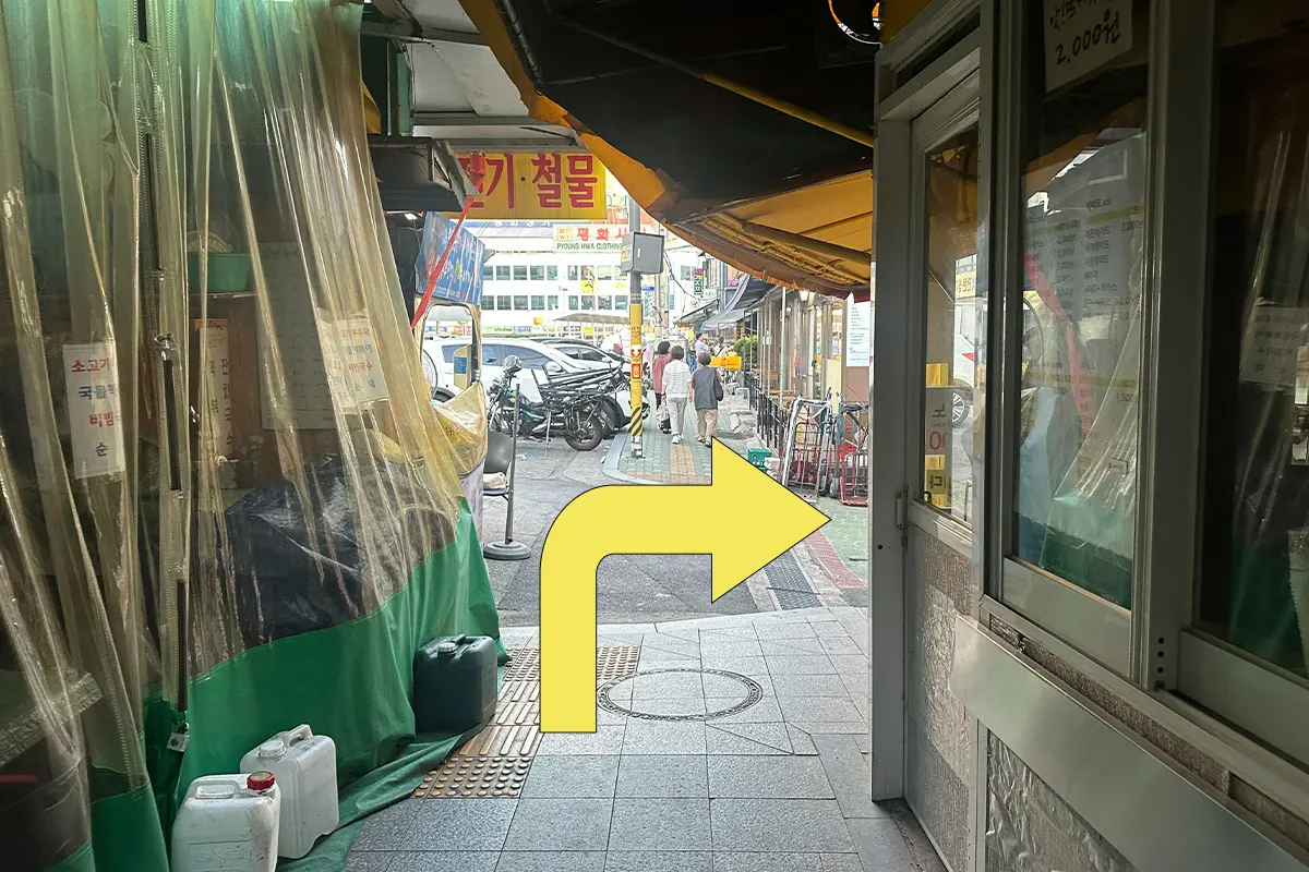 在市場內小巷直行的路徑，沿途看到許多攤販的桌椅及商店招牌。