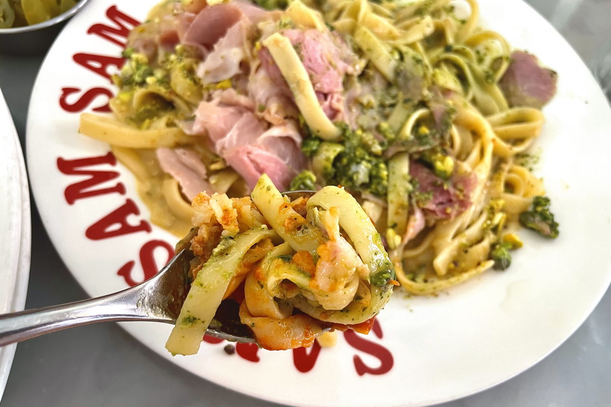 Jambon-beurre意大利面特写，展示了丰富的罗勒酱和火腿顶料。