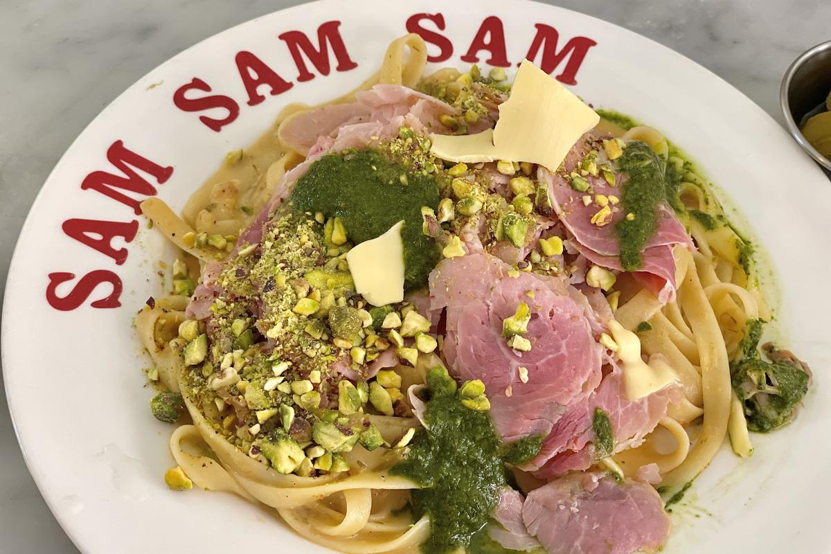 厨师在开放式厨房内烹饪，在SAM SAM SAM餐厅中可以看到食材的准备过程。