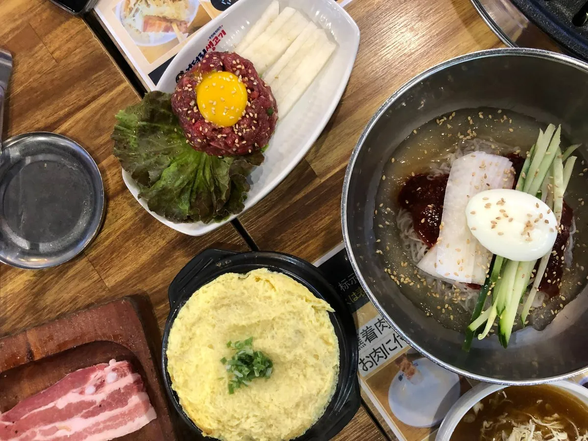 韓国料理のユッケとビビン冷麺、卵と野菜が乗った美味しそうな料理