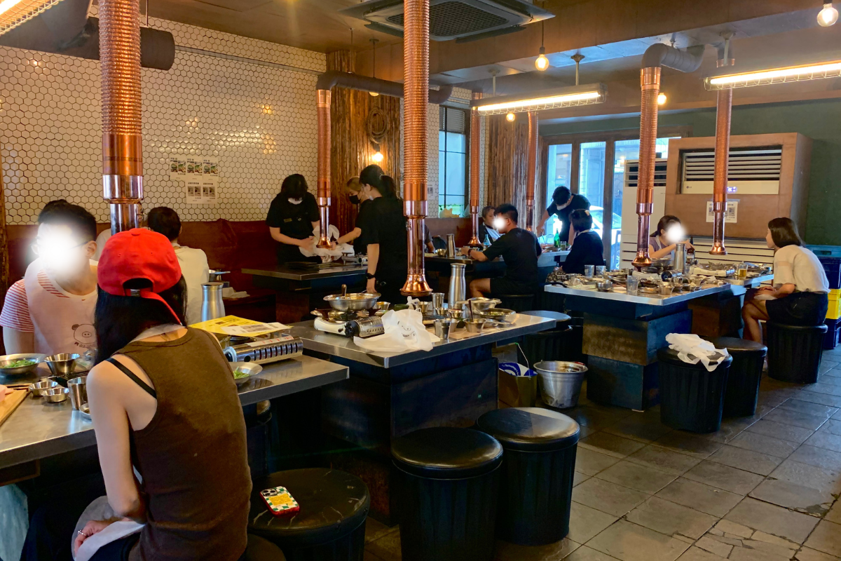 Ресторан Золотая Свинья с посетителями, наслаждающимися корейским барбекю.