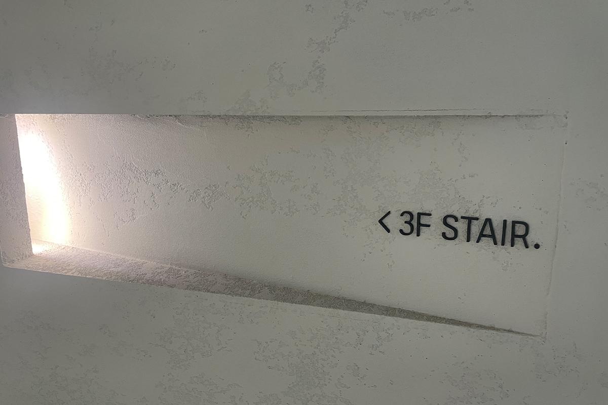 Weiße Stiegen führen zum zweiten Stockwerk des Yeoulmarq Cafe mit Meerblick.