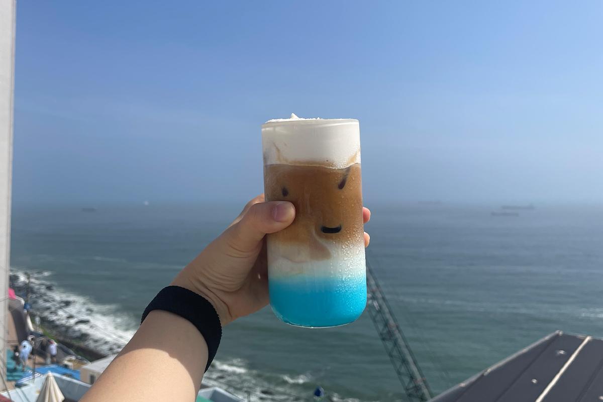 Markantes Designgetränk aus Yeoulmarq Cafe, dessen schichtiger Look die Farben des Meeres imitiert.