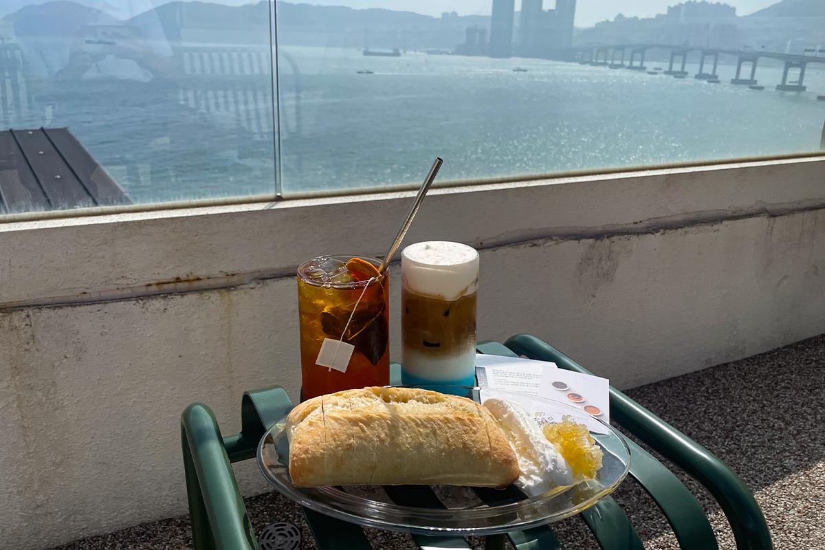 Erfrischendes Eiskaffeegetränk gefilmt gegen den Hintergrund des blauen Meeres.