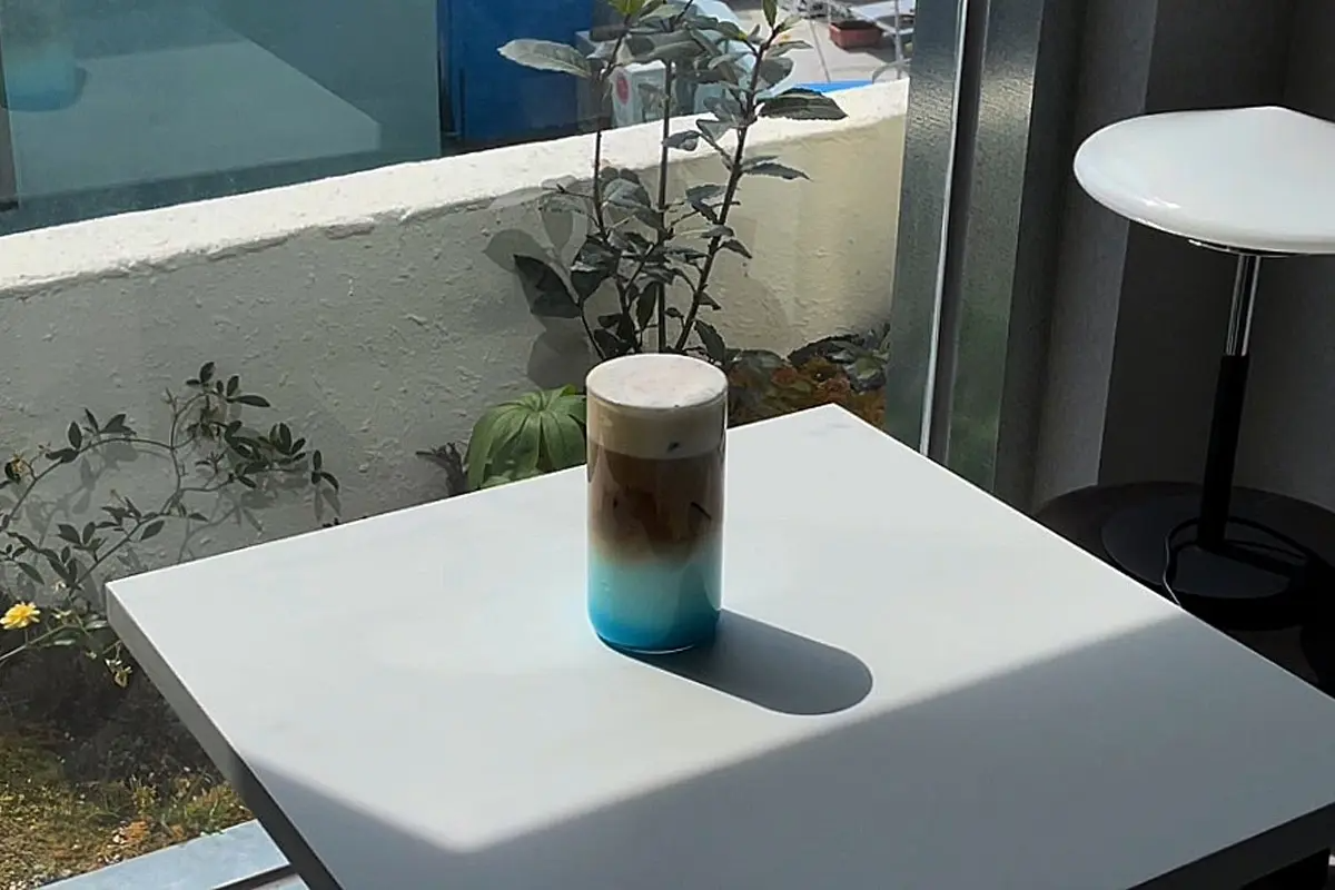 Helles Getränk im Yeoulmarq Cafe Busan bei direktem Sonnenschein auf einem Tisch.