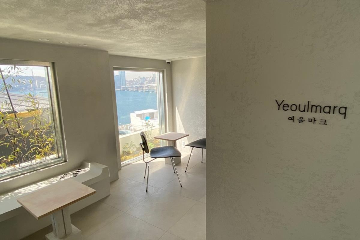 Modernes, minimalistisch eingerichtetes Yeoulmarq Cafe mit Blick auf das Meer in Busan.