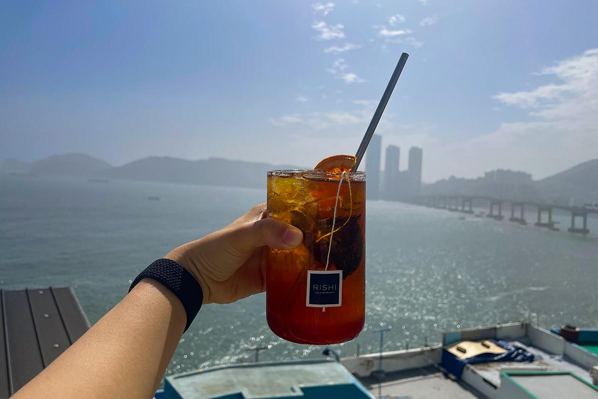 Ein erfrischender Honig-Grapefruit-Schwarztee mit Meeresblick im Hintergrund.