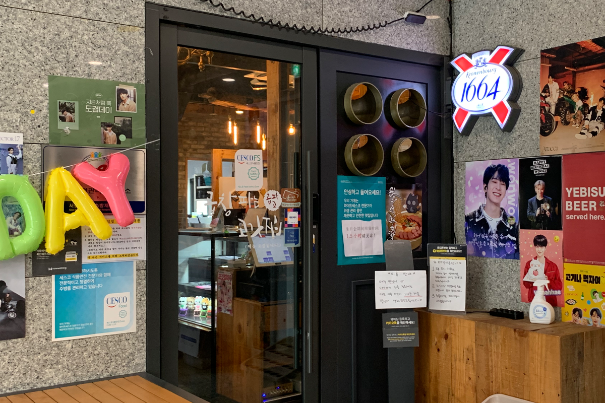 入口展示告示牌和韓國藝人海報的烤肉店