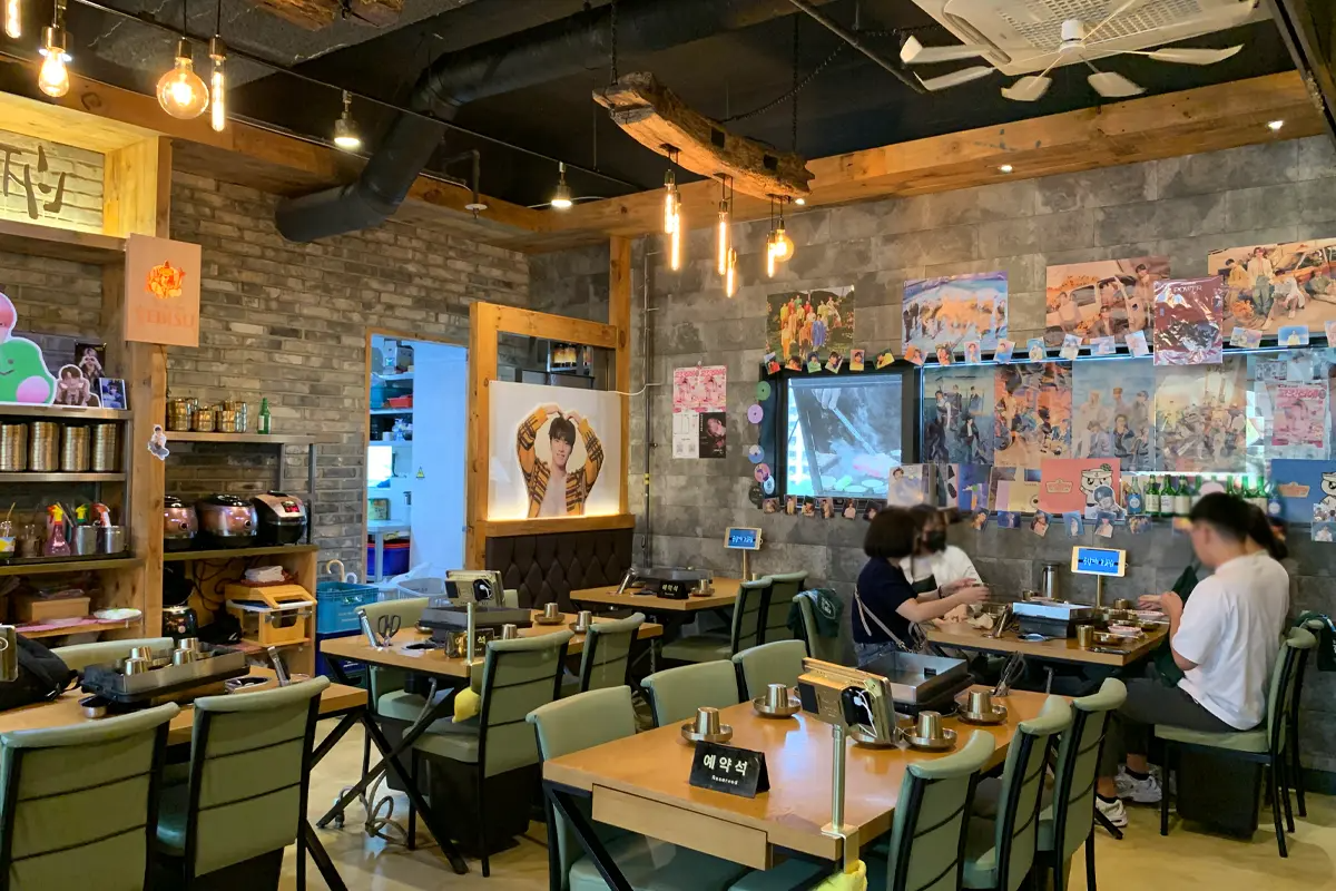 餐廳用餐區的整體照，角落展示牆上的偶像團體周邊