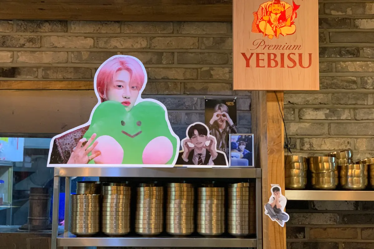 一個櫃台上擺放著韓國歌手照片與迎客裝飾品