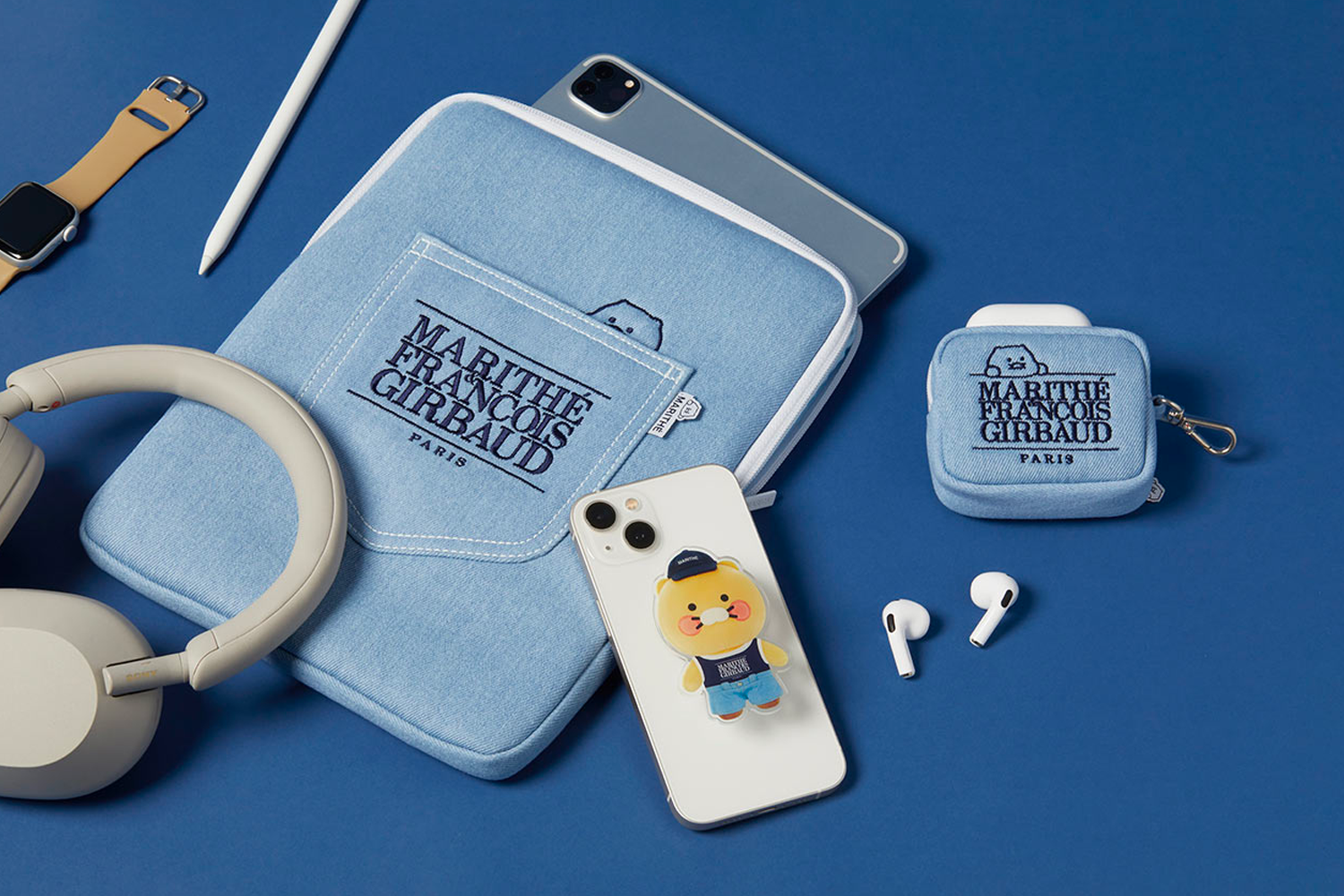 Marithe和Kakao Friends合作款生活用品展示：包括印有Marithe François Girbaud Logo的牛仔质感收纳包、耳机，以及贴有莱恩角色贴纸的手机壳，强调品牌的时尚与实用性。