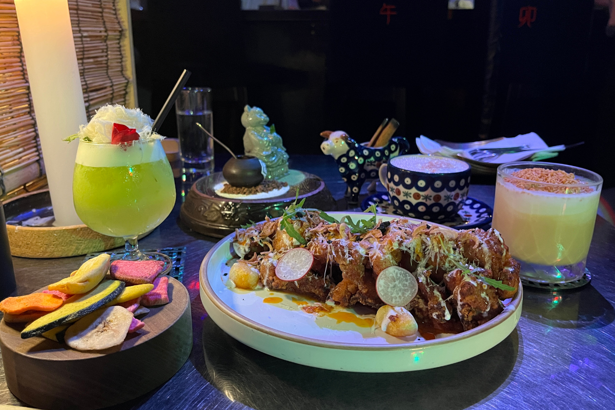 Современные коктейли и корейские деликатесы на столе в популярном баре в районе Хипдан-донг, Сеул.