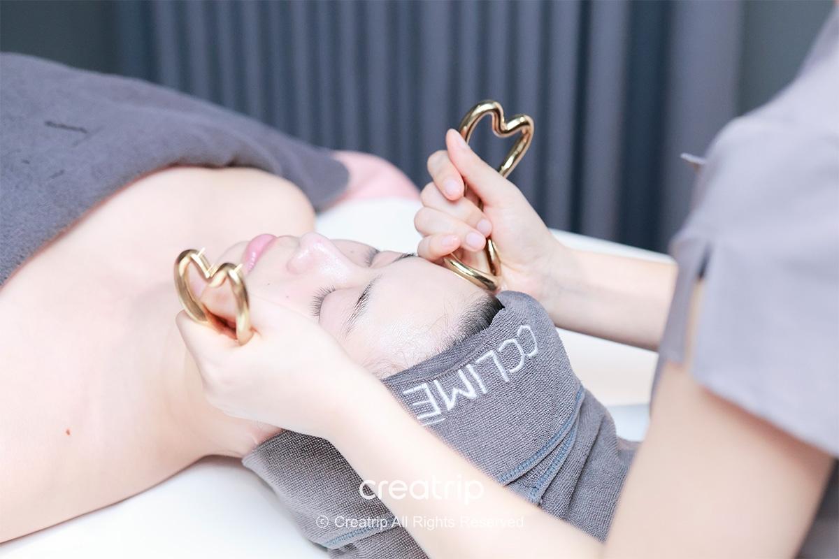 Client receiving a facial treatment with handheld tools at a beauty clinic