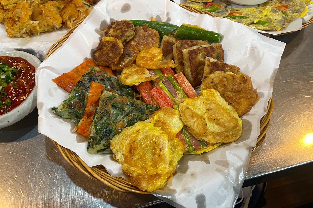 Ein großer Korb voller gemischter Jeon (koreanische Pfannkuchen) im Gwangjang-Markt in Seoul.