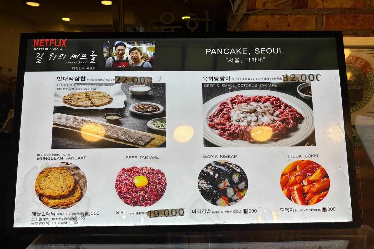 Ein Innenfoto der Parkgane Bindaetteok 2. Filiale in Seoul, zeigt eine Treppe und Getränkeauswahl.