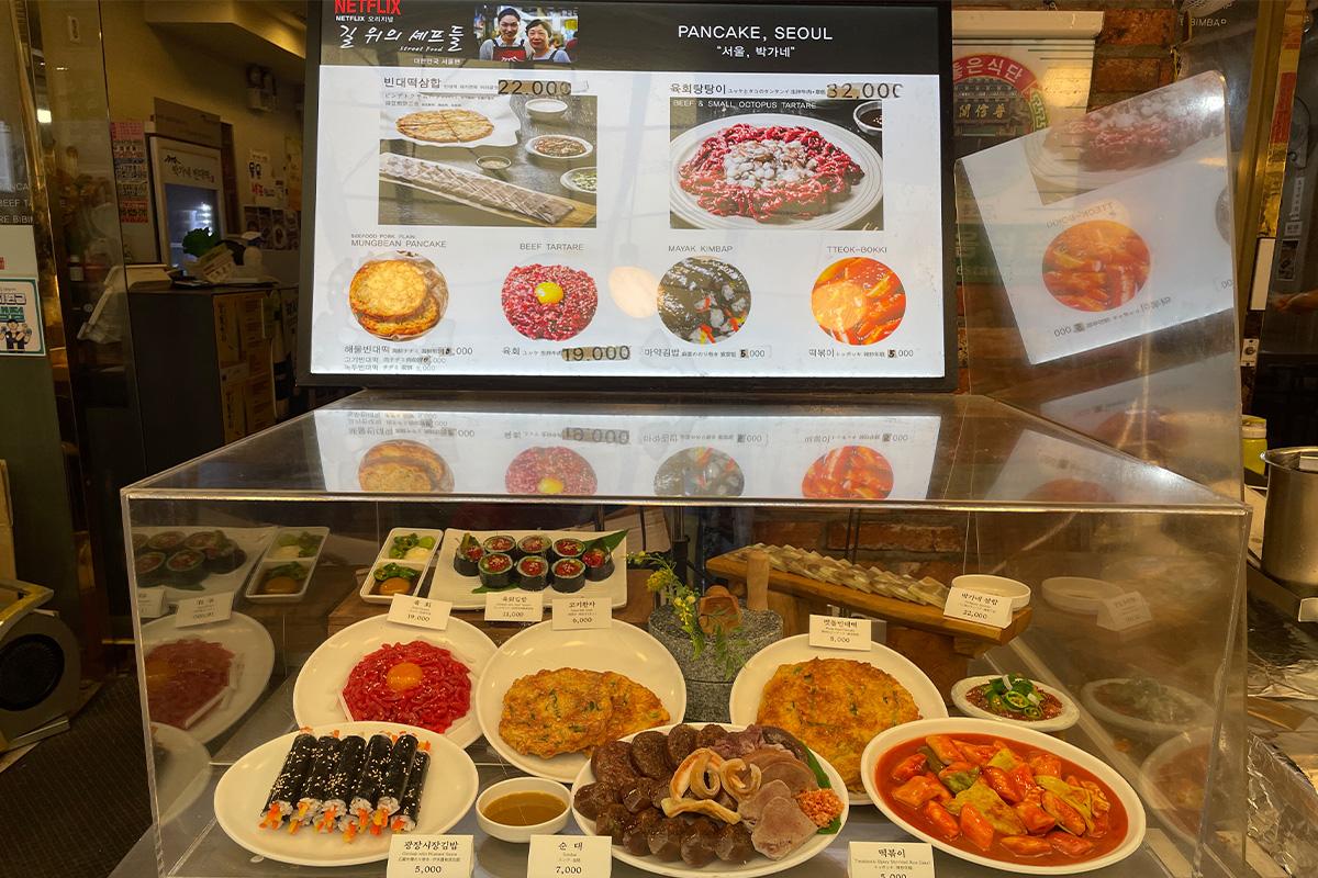 Ein Tisch voller Bindaetteok im Parkgane Bindaetteok auf dem Gwangjang-Markt in Seoul, Korea.