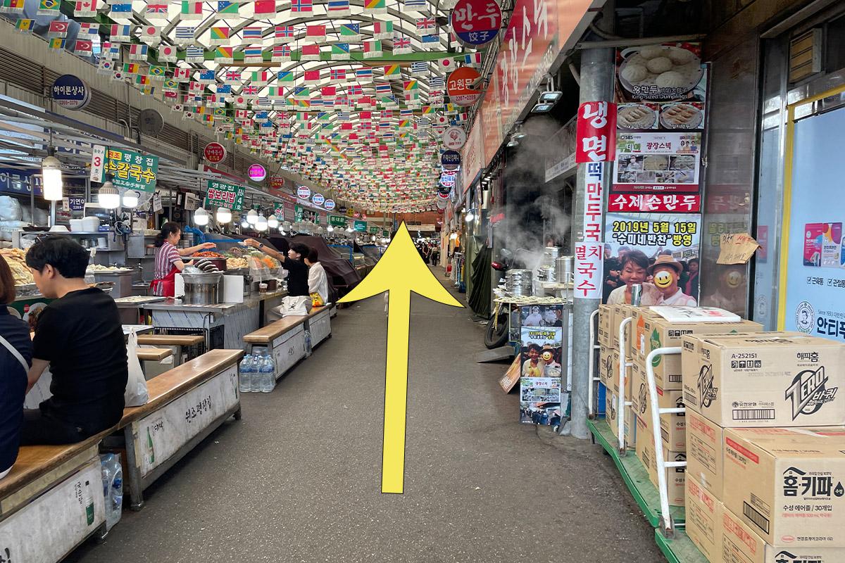 Ein weiterer köstlicher koreanischer Jeon, gehalten mit einem Paar Essstäbchen, serviert im Parkgane Bindaetteok auf dem Gwangjang-Markt.