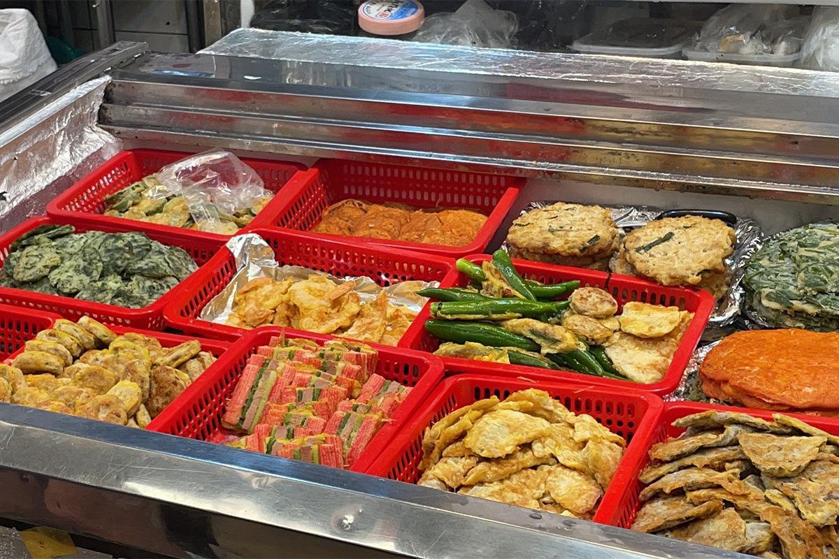 Eine Auswahl koreanischer Pfannkuchen, die am Eingang des Parkgane Bindaetteok auf dem Gwangjang-Markt in Seoul ausgestellt sind.