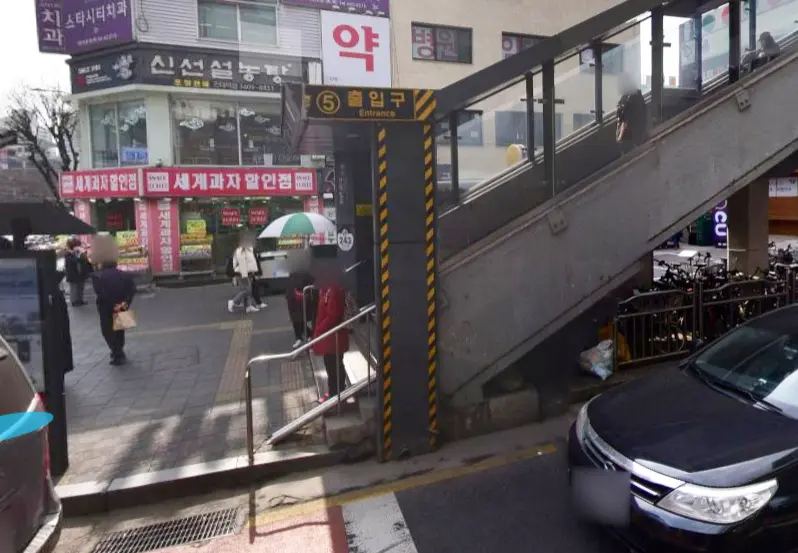 首爾建大入口地鐵站5號出口，背景有商店街道