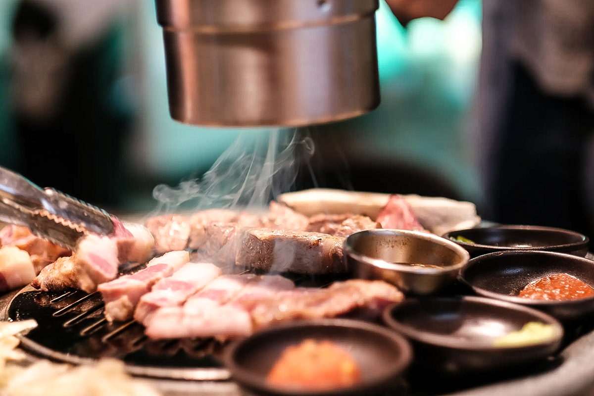 濟州島「熟成到」餐廳內展示的烤肉食材，包括新鮮的豬肉切片和蘑菇。