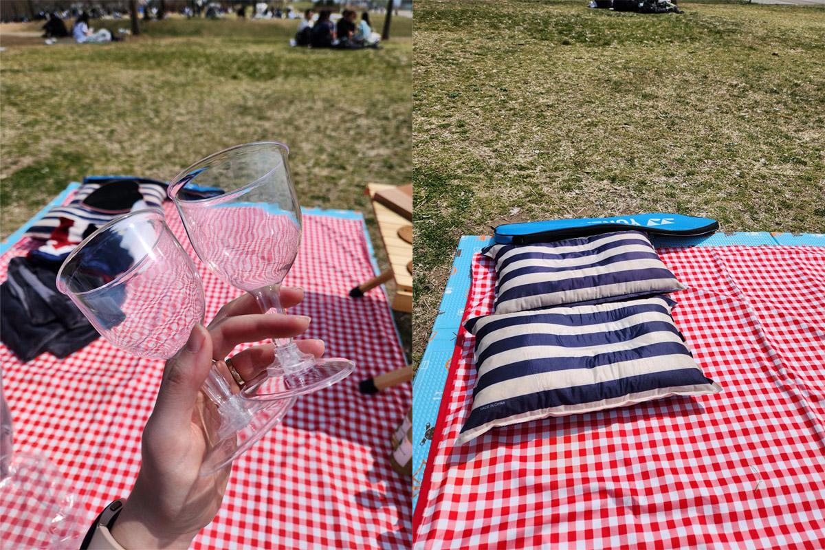Picnic food setup on a wooden table with a backdrop of Han River and a pink heart-shaped mirror.