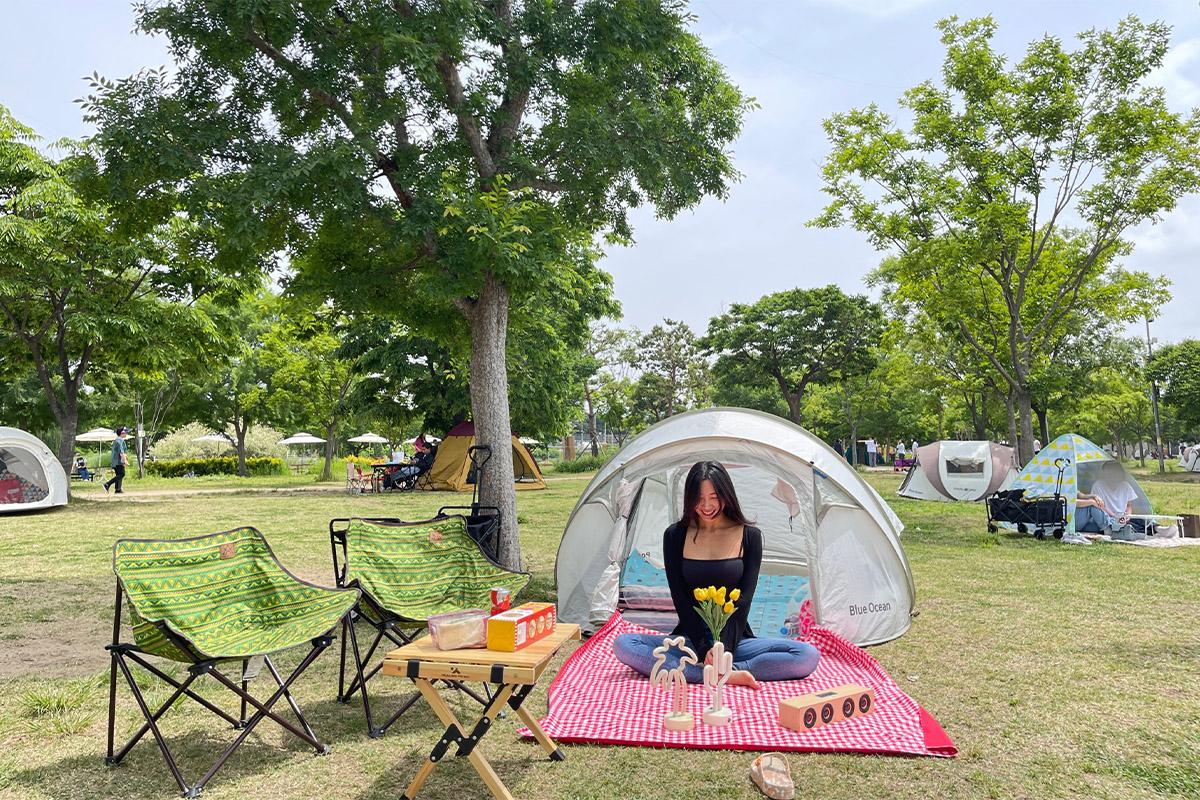 Blue-themed interior of a tent with pillows and cloth representing a relaxing riverside picnic.
